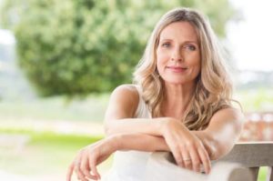 Woman Leaning on Chair Looking at Camera